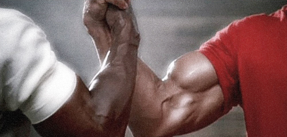 A shot of Arnold Schwarzenegger and Carl Weathers' arms while arm wrestling in the movie The Predator